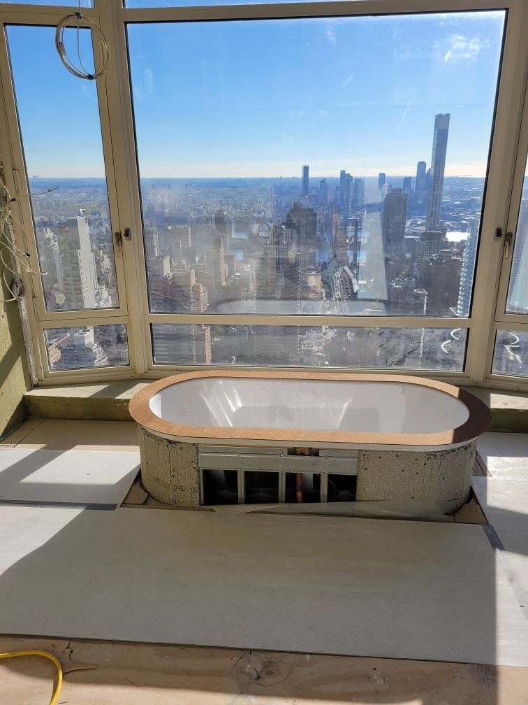 Freestanding tub in a high-rise bathroom with a view over the Manhattan skyline
